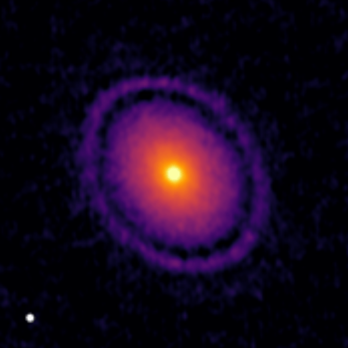 ALMA Image of protoplanerary discs GW Lup, showing bright inner regions in yellow/orange and some rings in the outer disc in purple.